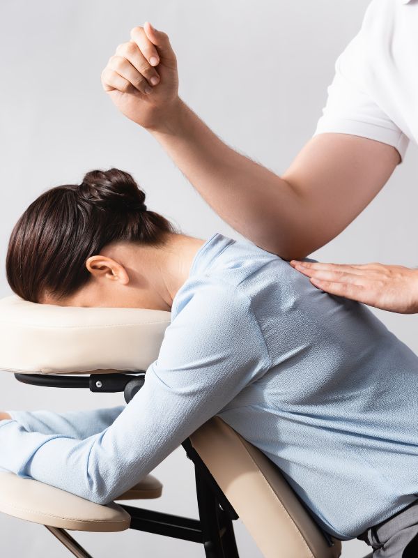 A woman receiving a specialist massage therapy in a chair.