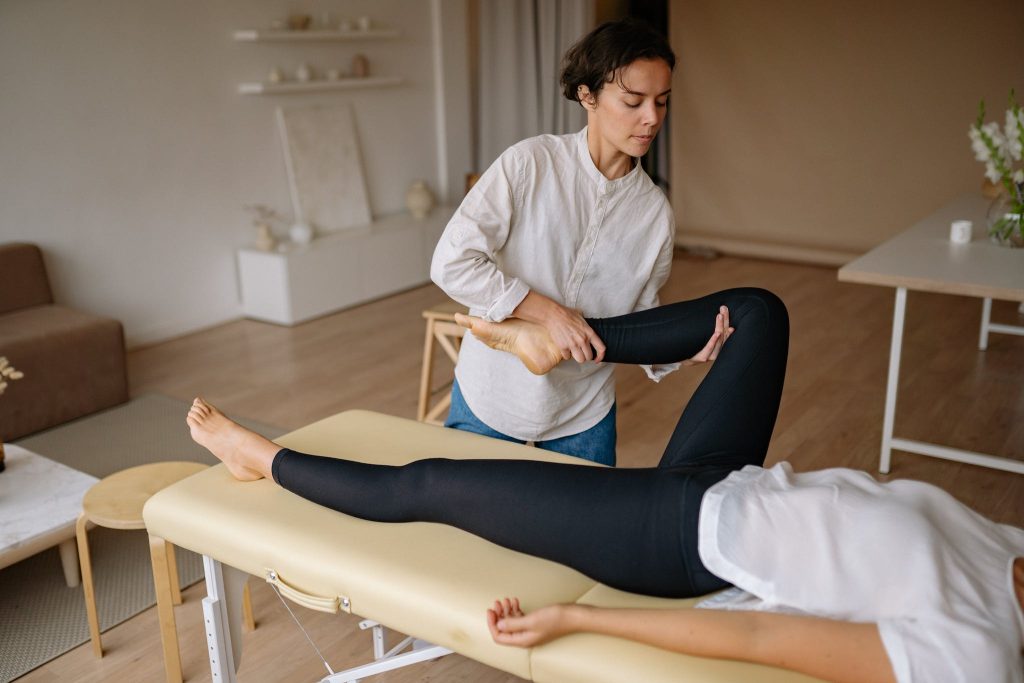 A Thai Massage Therapist Massaging the Leg of a Client