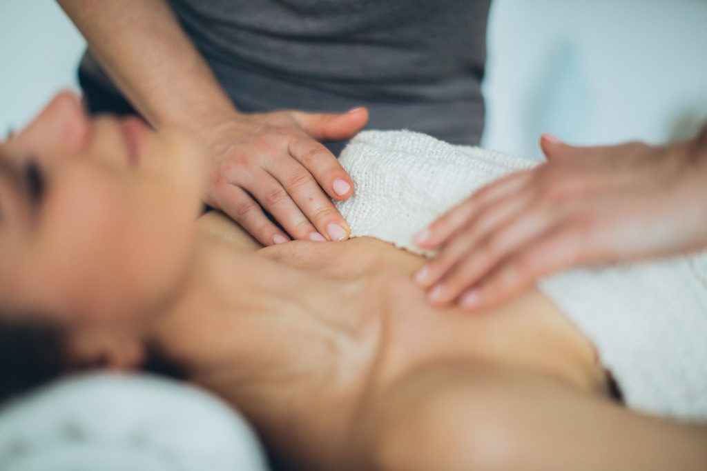 A Therapist massaging Woman's Chest